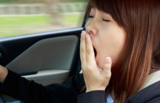 Drowsy driver yawning while driving