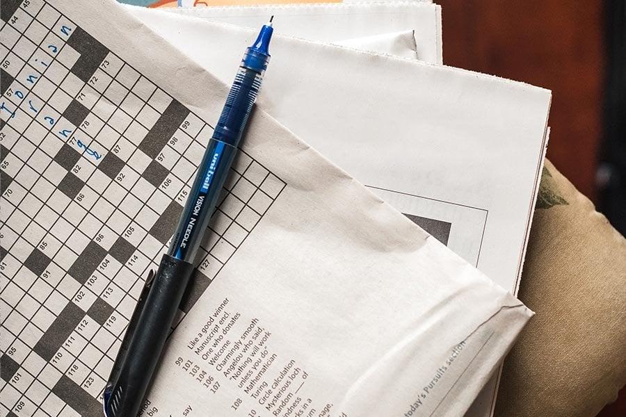 Crossword puzzle shown with pencil on top of paper